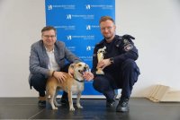 Burmistrz Aleksandrowa, policjant ze statuetką oraz adoptowany pies Aleks.