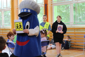 Maskotka Komisarza Błyska pokazuje dzieciom znak drogowy