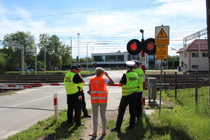 funkcjonariusze stoją przy sygnalizatorze, który wyświetla czerwony sygnał świetlny