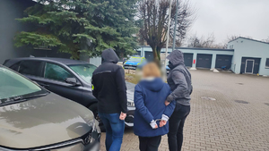 Policjanci prowadzą zatrzymaną.