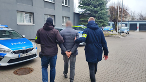 Policjanci prowadzą zatrzymanego.