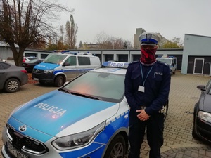 umundurowany policjant stoi obok radiowozu