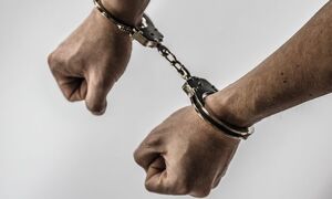 ręce spięte kajdankami policyjnymi