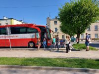 Osoby czekające w kolejce przed autobusem krwiodawstwa.