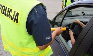 Policjant sprawdza stan trzeźwości kierującego.