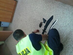 policjant podczas oględzin zabezpieczonej broni