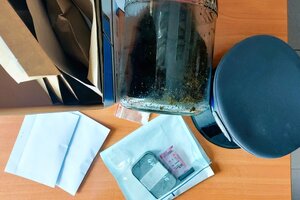 Zabezpieczone środki odurzające oraz czapka policyjna na biurku