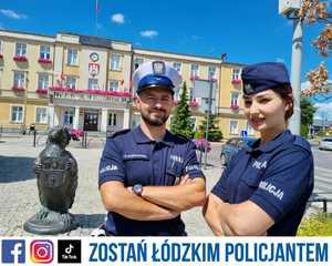 Dwoje policjantów. W tle budynek oraz statuetka jeża.