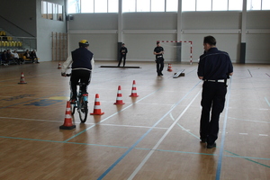 uczestnik na rowerze pokonuje slalom pomiędzy słupkami