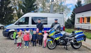 policjanci z przedszkolakami przy radiowozie i motocyklu policyjnym