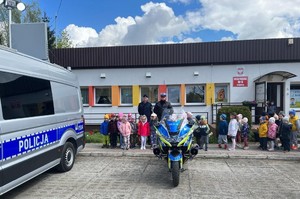 policjanci z przedszkolakami przy radiowozie i motocyklu policyjnym