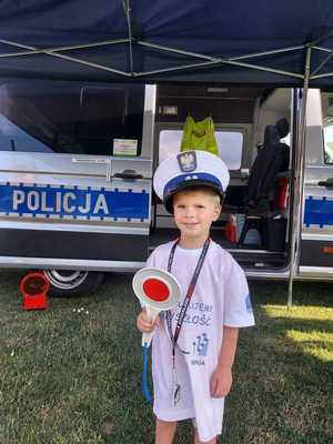 dziecka z czapką policjanta i tarczą do zatrzymywania pojazdów