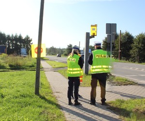 policjantka i policjant stoją w rejonie przejścia dla pieszych.