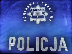 Napis Policja i pomagamy i chronimy na niebieskim tle