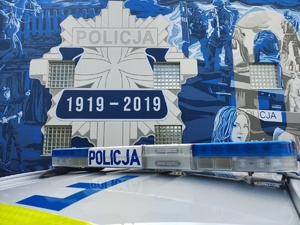 radiowóz policyjny na tle muralu z gwiazdą policyjną