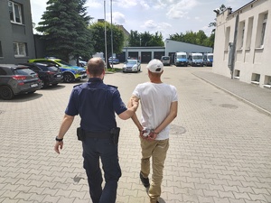 Policjant prowadzi zatrzymanego