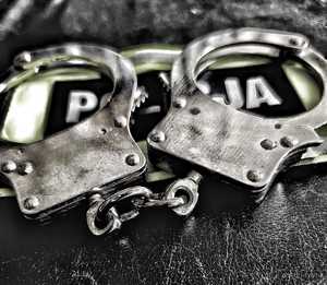 Kajdanki na opasce z napisem Policja