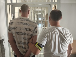 Policjant z zatrzymanym przed policyjna celą
