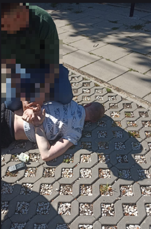 policjant zakłada kajdanki zatrzymanemu