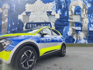 Radiowóz na tle muralu z gwiazdą policyjną