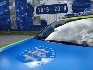 Radiowóz na tle muralu z gwiazdą policyjną
