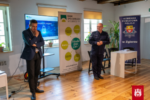 Funkcjonariusz Komendy Powiatowej Policji w Zgierzu i pracownik Banku Spółdzielczego na spotkaniu z seniorami.