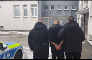 Policjanci przewożą zatrzymanego do Sądu
