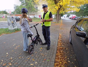 Policjant wręcza kask dziecku